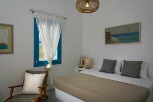 - une chambre avec un lit, une fenêtre et une chaise dans l'établissement Zefiros, à Karavostasi