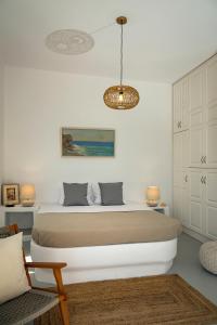1 dormitorio con cama y lámpara de araña en Zefiros, en Karavostasi