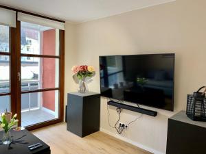 uma sala de estar com uma grande televisão de ecrã plano na parede em Kleiner Koenig - Appartement im Stadtzentrum em Bochum