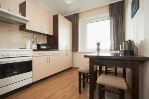 a kitchen with a table and a window and a stove at Cozy private room in a three room apartment Free parking Feel like at home in Vilnius