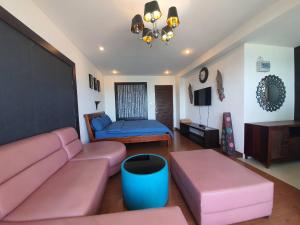 a living room with a pink couch and a bed at Banchaitalay Room in Rayong