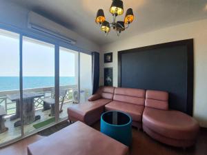 a living room with a couch and a view of the ocean at Banchaitalay Room in Rayong