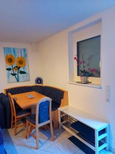 a small dining room with a table and a bench at FeWo zwischen Freiburg und Europa Park Rust nur 200m zur S-Bahn in Bahlingen