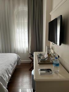 a hotel room with a bed and a table with a television at Salbakos Herakleia Hotel in Alacati