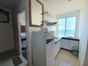 a kitchen with a sink and a window with the ocean at Banchaitalay Room in Rayong