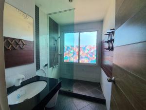 a bathroom with a large tub and a window at Banchaitalay Room in Rayong