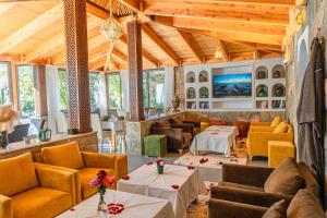 a large room with couches and tables and windows at Dar Hnini in Zagora