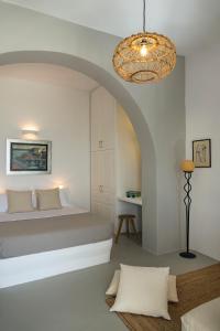 1 dormitorio con cama y lámpara de araña en Maistros, en Karavostasi