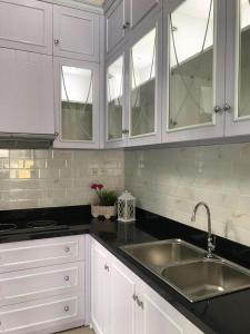 een keuken met witte kasten en een wastafel bij New 3br The Green Home in Kepiting-kidul