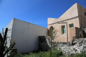 a building on the side of a stone wall at Peaceful 2 bedroom heritage vacation house in Nikiá