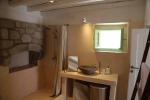 a bathroom with a sink and a window at Peaceful 2 bedroom heritage vacation house in Nikiá