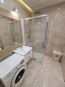 a bathroom with a washing machine and a shower at Apartament Godebskiego 1b in Lublin