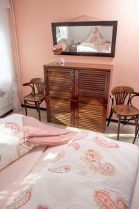ein Schlafzimmer mit einem Bett und eine Kommode mit einem Spiegel in der Unterkunft Haus Haeger in Dahme