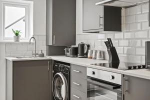 a kitchen with a washing machine and a sink at Luxnightzz - Stylish Boutique 1 Bed Apartment in Gravesend