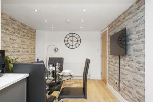 a dining room with a table and a clock on the wall at Luxnightzz - Stylish Boutique 1 Bed Apartment in Gravesend