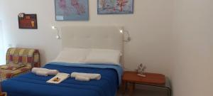 a bedroom with a blue bed with towels on it at In Vacanza a Gaeta - Libera Stella in Gaeta