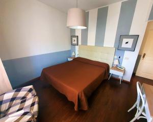 a bedroom with a bed in a room with striped walls at Hotel Le Focette in Marina di Pietrasanta