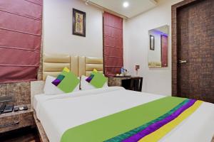 高哈蒂的住宿－Itsy By Treebo - Ransu Residency，卧室配有一张带彩色枕头的大型白色床。