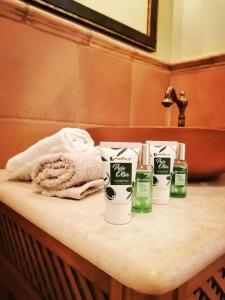 a bathroom counter with four bottles of soap and towels at Gaia accomodation Hydras in Hydra
