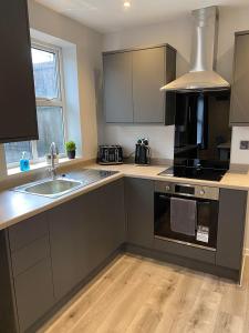 a kitchen with a sink and a stove at Spacious & modern 3 bed house in Stafford