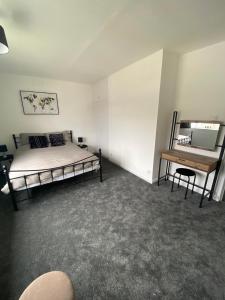 a bedroom with a bed and a desk in it at Spacious & modern 3 bed house in Stafford