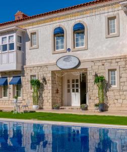 a building with a swimming pool in front of it at Salbakos Herakleia Boutique Hotel in Alacati