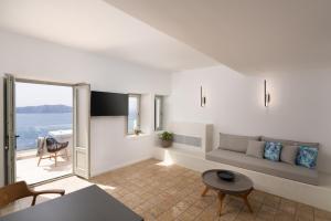 un soggiorno con un divano e un tavolo di Asha Luxury Suites a Firà