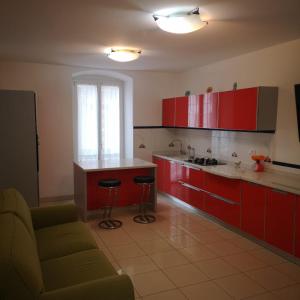 ラ・スペツィアにあるSTELLA MARINAのキッチン(赤いキャビネット、ソファ、テーブル付)