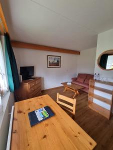 uma sala de estar com uma mesa de madeira e um sofá em Hotel Roc et Neige em Château-d'Oex