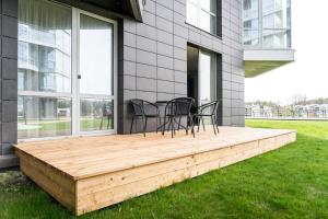a deck with chairs and a table on a house at SimSim Apartamentai in Šventoji