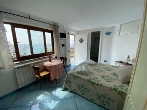 a bedroom with a bed and a table and a window at Le Dimore di Zaro - Green Paradise in Forio d'Ischia +77 photos
