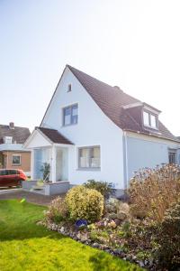a white house with a garden in the yard at Haus Haeger in Dahme