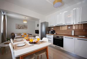 a kitchen and a living room with a table and chairs at Sea Front Apartments Ivana in Rogoznica