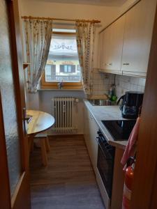 una pequeña cocina con mesa y ventana en Ferienwohnung Bayrischzell en Bayrischzell