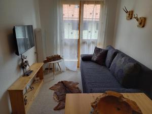 a living room with a blue couch and a table at Ferienwohnung Bayrischzell in Bayrischzell