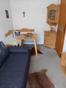 a living room with a blue couch and a table at Ferienwohnung Bayrischzell in Bayrischzell