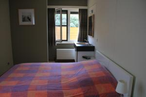 a bedroom with a bed and a sink and a window at Apartment Cuypers in Oostduinkerke
