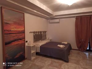 カステッランマーレ・デル・ゴルフォにあるCasa Chiarenzaのベッドルーム1室(ベッド1台付)が備わります。壁には絵画が飾られています。