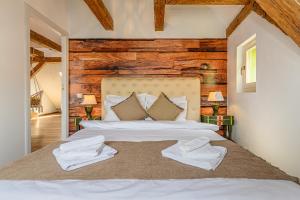Historical GuestHouse في براشوف: غرفة نوم عليها سرير وفوط بيضاء