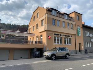 Železný BrodPenzion Vesely的停在酒店门前的一辆汽车