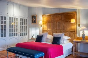 a bedroom with a large bed with a wooden headboard at La Baronnie Hôtel & Spa - Teritoria in Saint-Martin-de-Ré