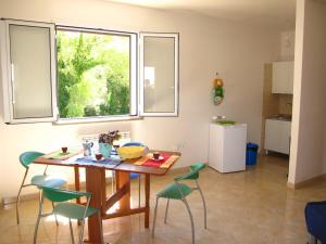 tavolo e sedie in cucina con finestra di Otranto Vacanza Facile - Via delle Memorie a Otranto