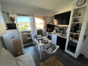 a small kitchen with a table and a counter top at Azur, a 100m du marché de Noel, appartement 4 personnes et parking privé in Le Barcarès