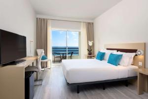 Cette chambre d'hôtel comprend un lit et offre une vue sur l'océan. dans l'établissement TRYP by Wyndham Lisboa Caparica Mar, à Costa da Caparica
