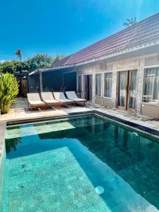 una piscina con 2 sillas junto a una casa en GiliZen Resort - Private Pool Villas, en Gili Air