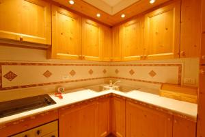a kitchen with wooden cabinets and a white counter top at Casa MARGHERITA Rainalter in Madonna di Campiglio +19 photos