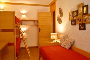 a bedroom with a bed and a bunk bed with a ladder at Casa MARGHERITA Rainalter in Madonna di Campiglio