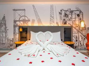 a bedroom with a bed with two hearts at Mercure Cardiff North Hotel in Cardiff