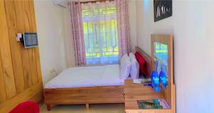 Habitación pequeña con cama y ventana en Mkomazi Hotels and Camps, en Hegoma