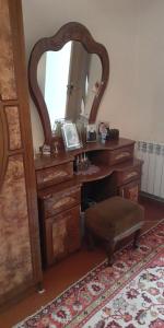 a dressing table with a mirror and a stool at Guest House OTILIA in Gyumri